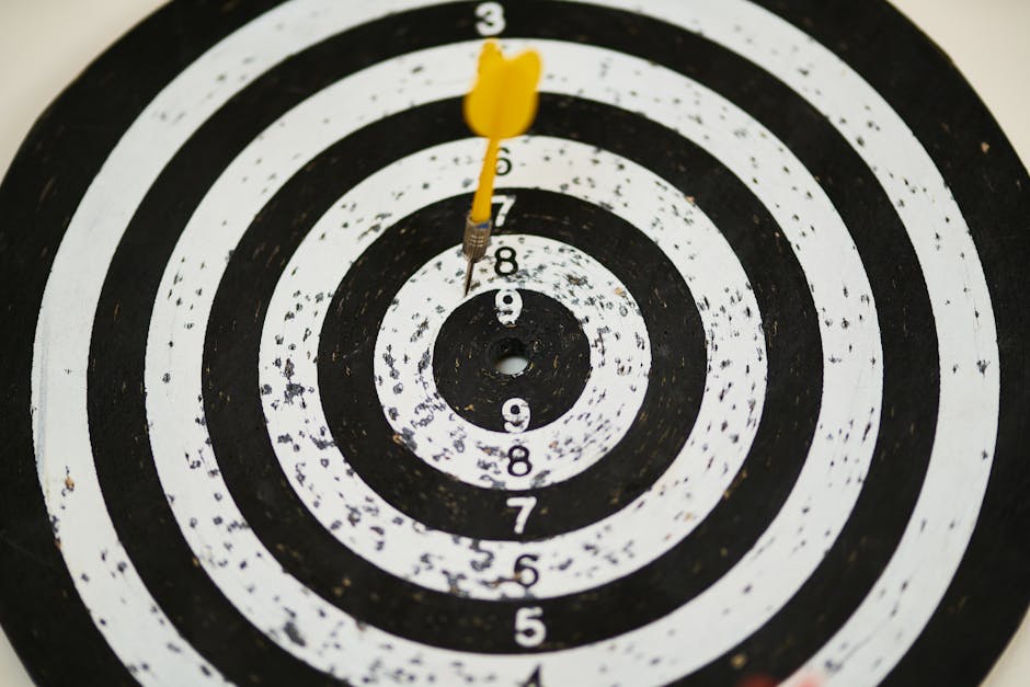 pexels-photo-1552617-1552617 Close-up of a dart hitting the bullseye on a black and white target board symbolizing success.
