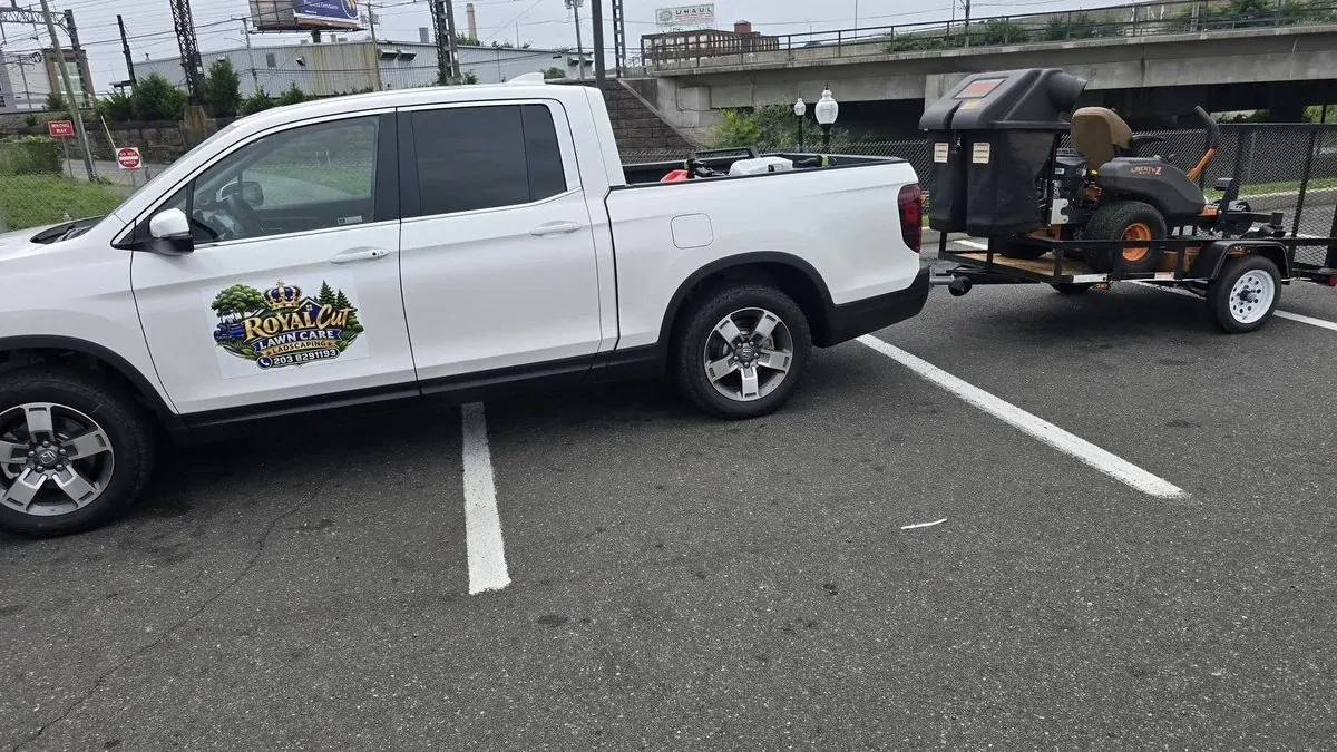 One man lawn care business truck and trailer parked on a job
