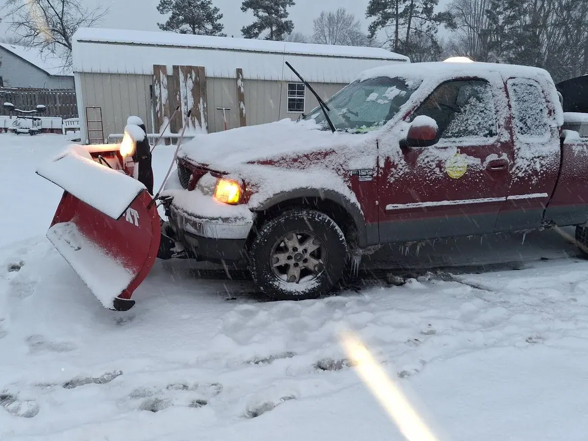 Pickup truck fitted with a snow plow working in winter snow