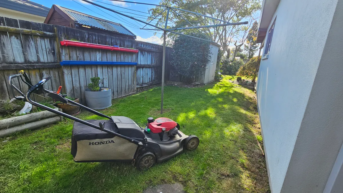 Honda mower on a lawn beside the house