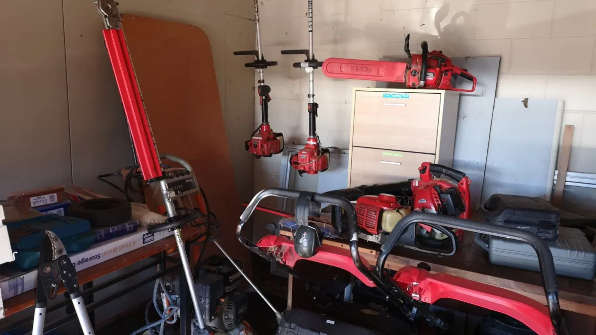 Inside a mower repair shop with line trimmers and chainsaws on the wall, one place to meet local contractors