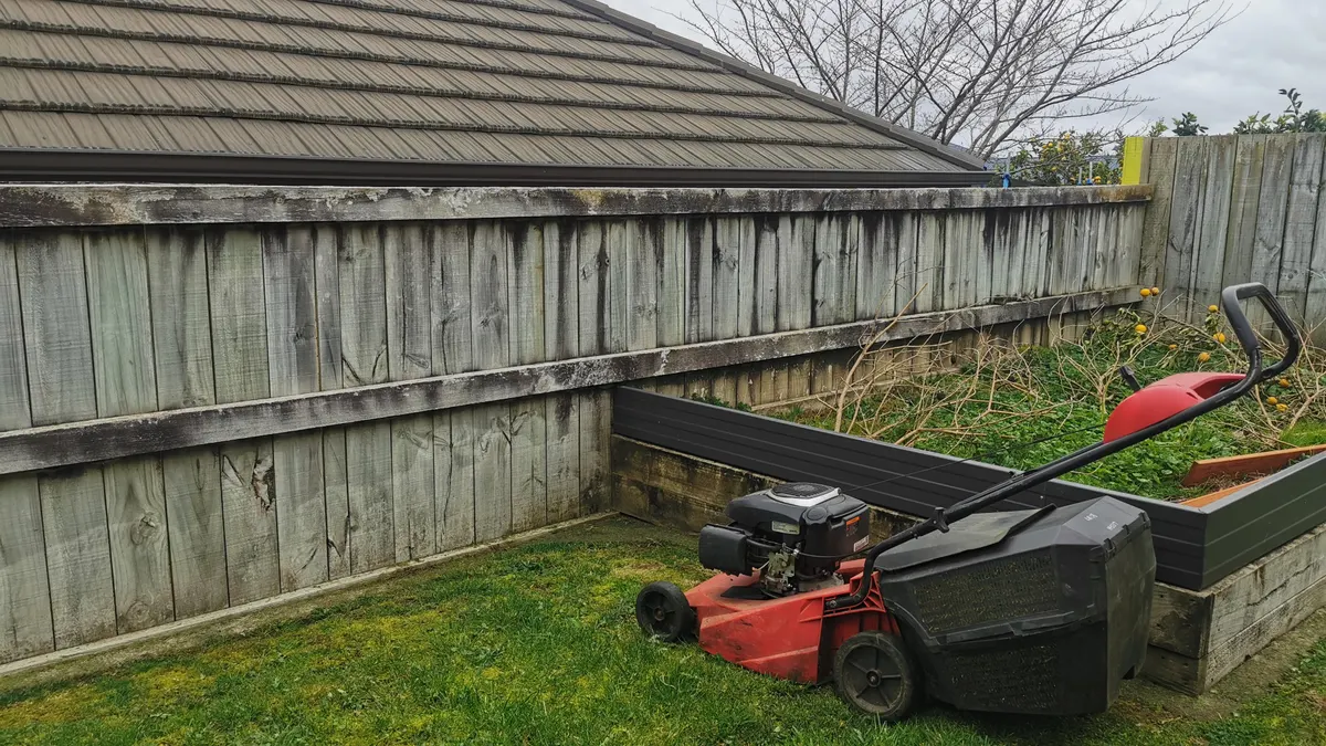 Push mower along a back fence