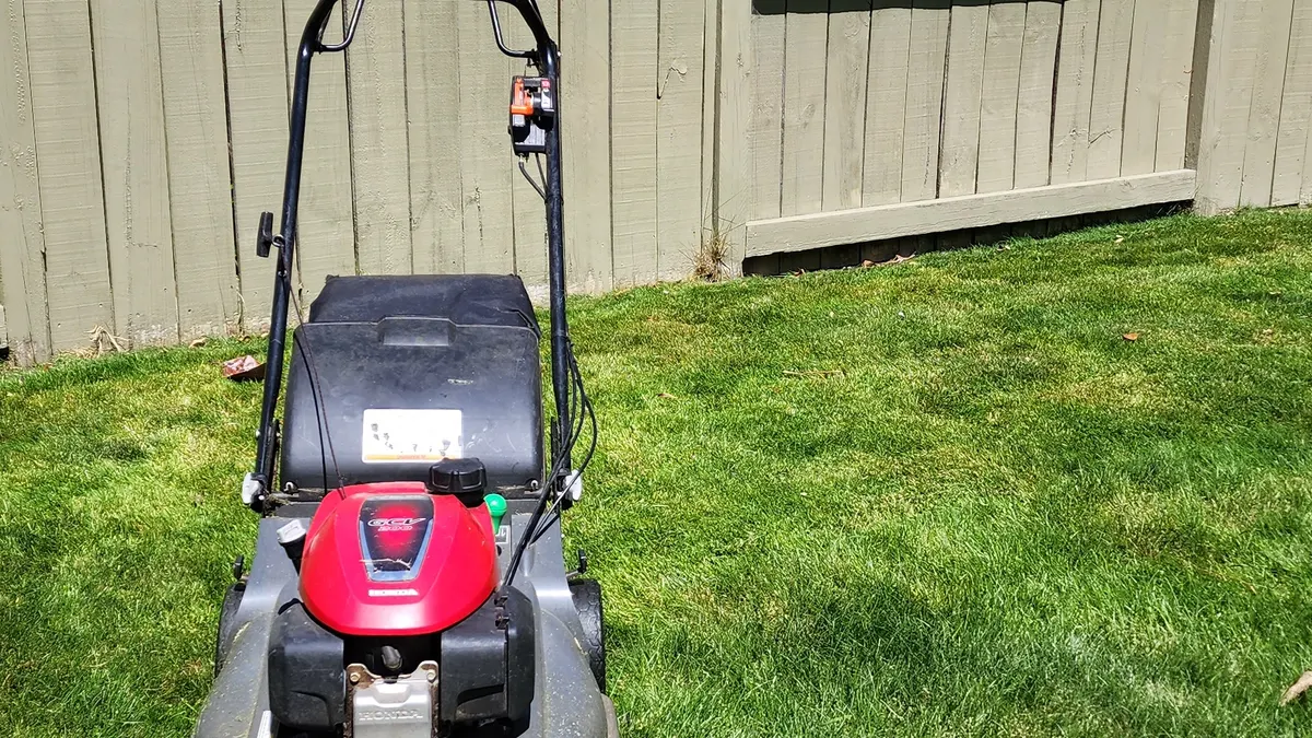 Honda mower against a back fence
