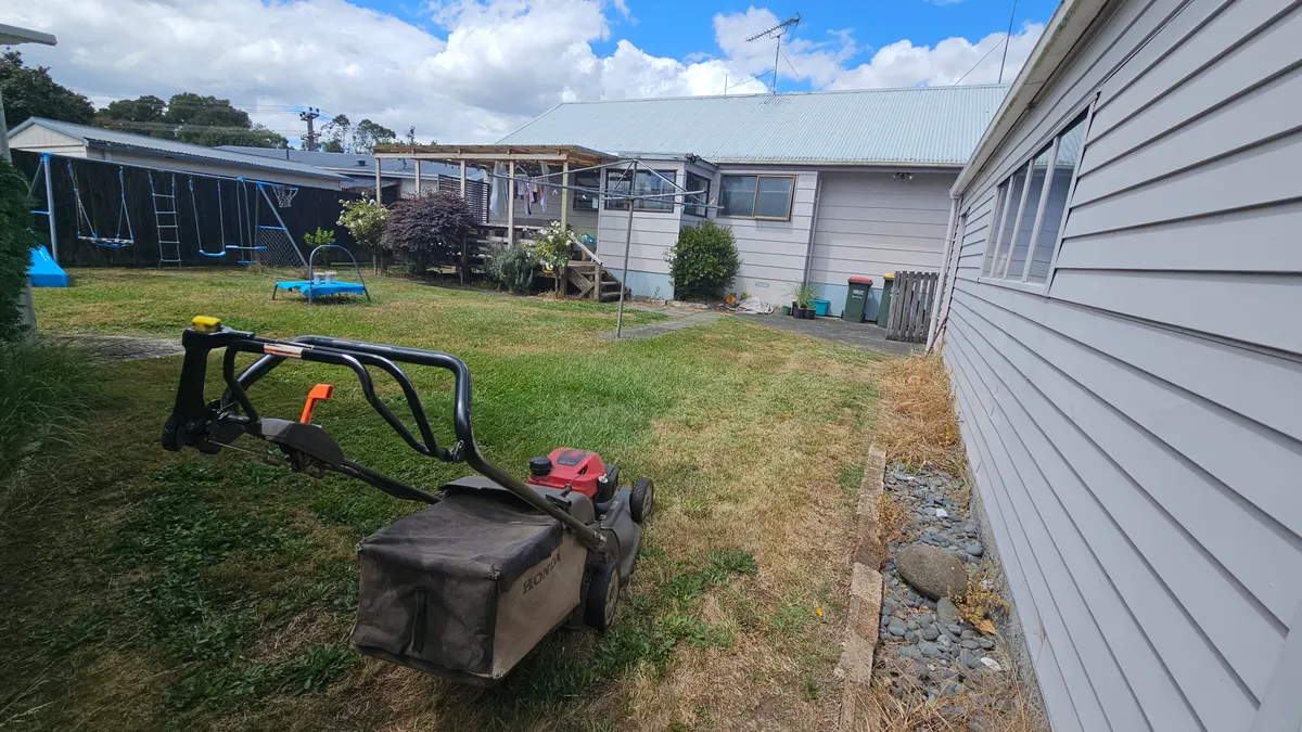 Mower on a back lawn by the house