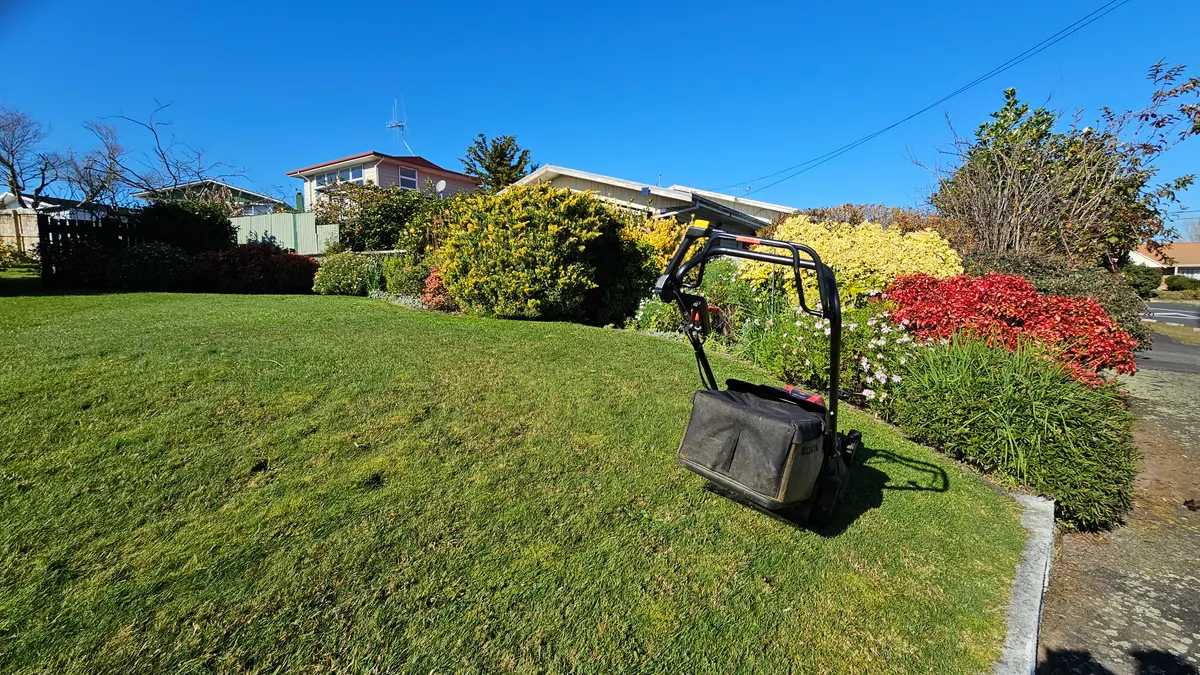 Mower on a sunny sloping lawn