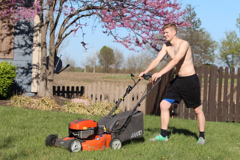 Kid mowing a lawn. Cheap labor