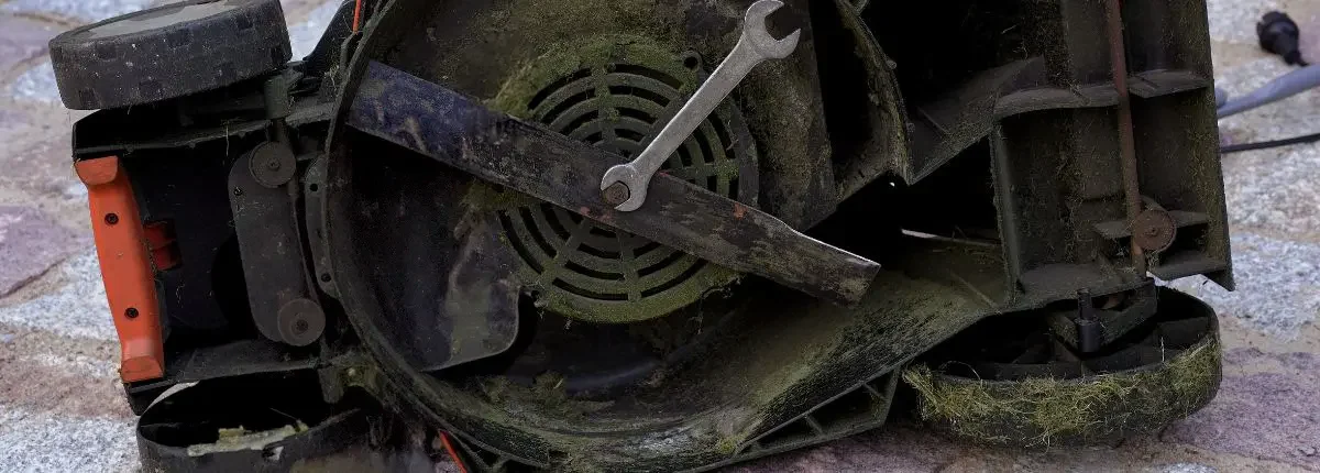 The lawn mower tipped over, showing the blades