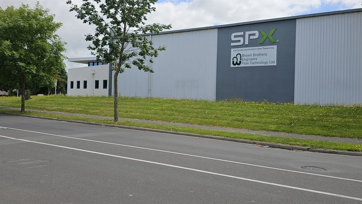 Overgrown grass verge outside a commercial warehouse frontage