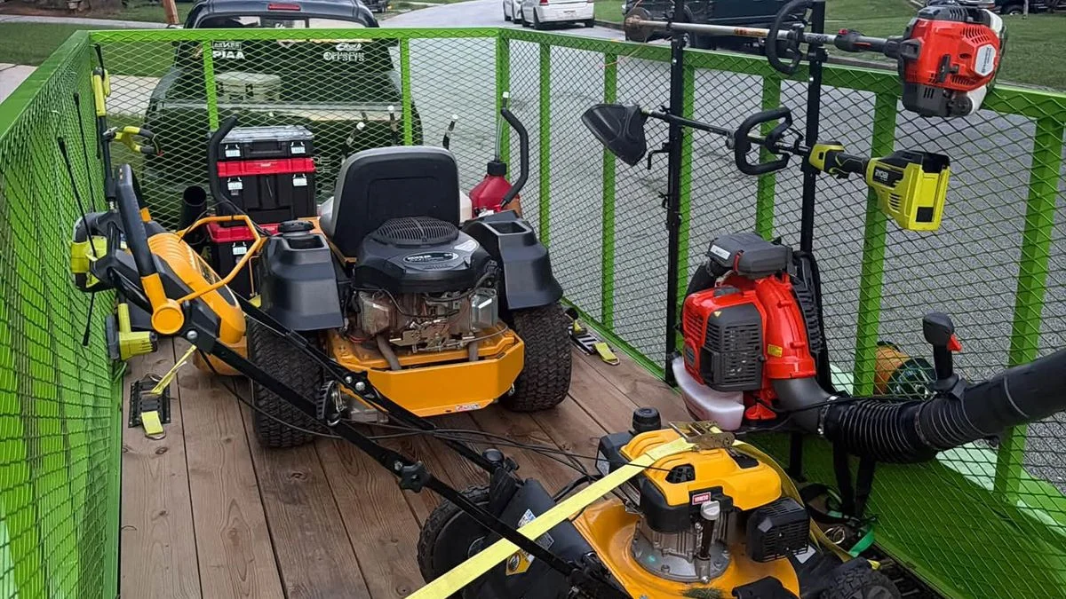 Solo lawn care operator's trailer loaded with mowers and gear
