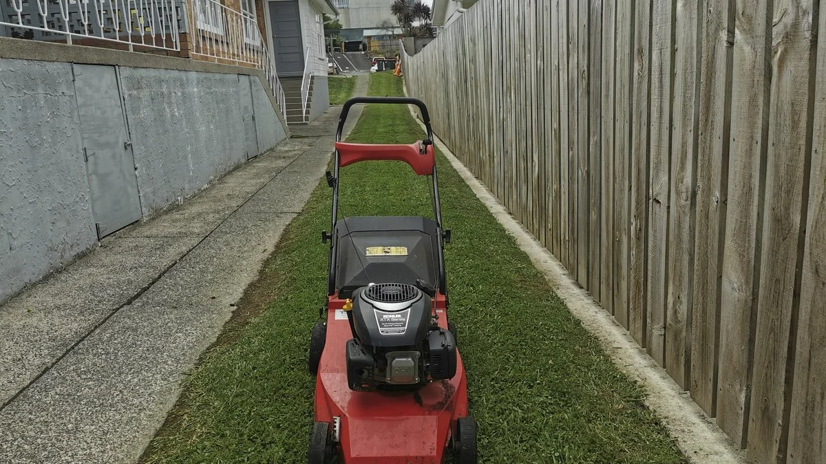 Push mower working a small narrow side lawn