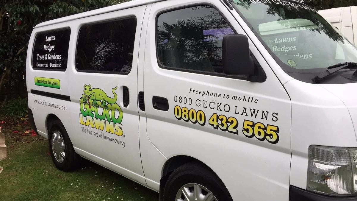 Signwritten lawn care van with the business phone number on the side