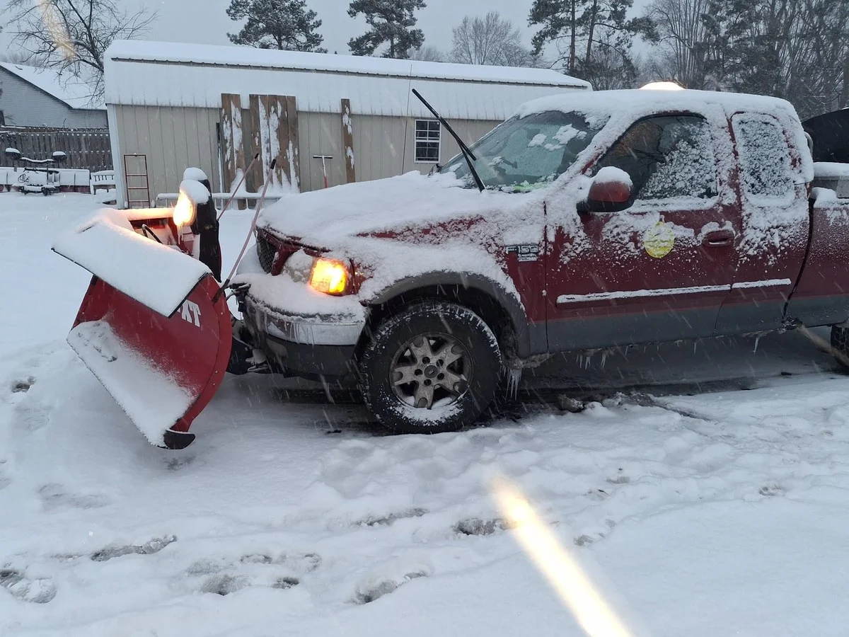 Pickup truck fitted with a snow plow working in winter snow