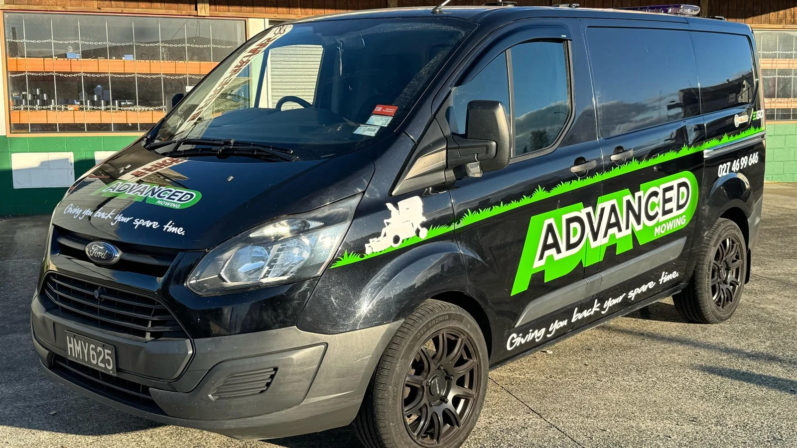 Advanced Mowing signwritten black van with the phone number on the side, the vehicle that does the talking on the street